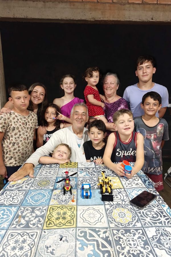 Família numa mesa de azulejos, com muitas crianças