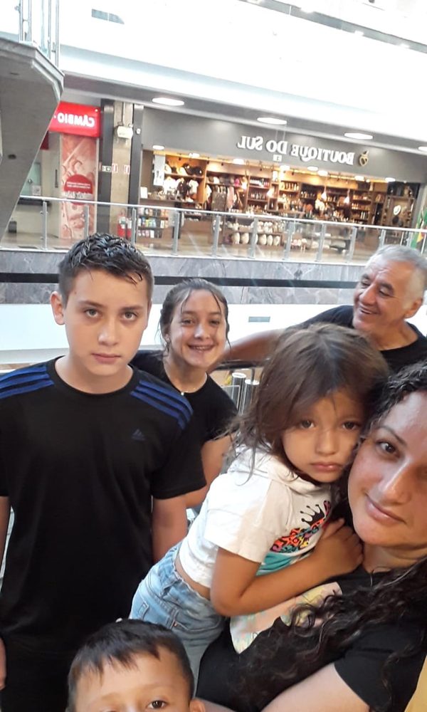 Selfie num shopping, com Sinval ao fundo sorrindo para os netos