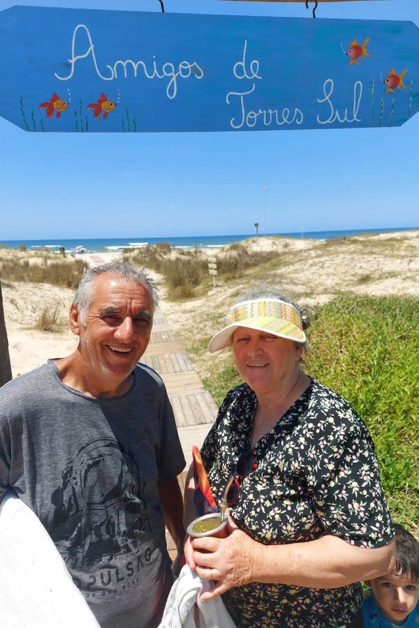Sinval e uma mulher sob a placa Amigos de Torres Sul