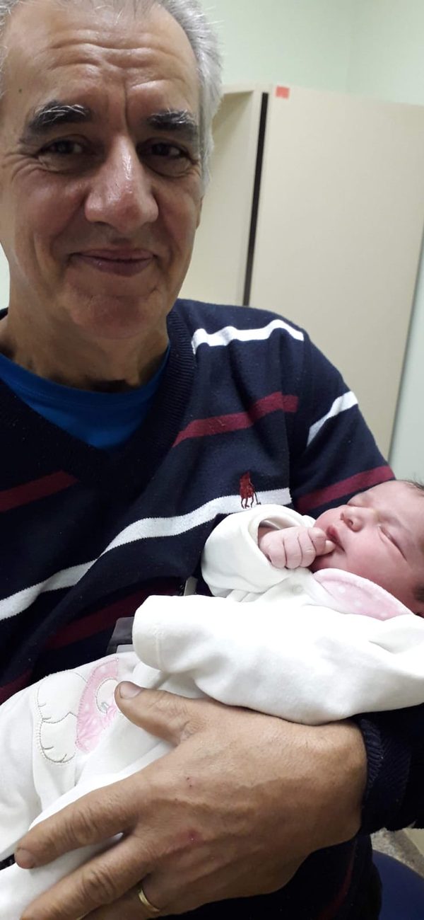 Sinval com um bebê recém-nascido no colo