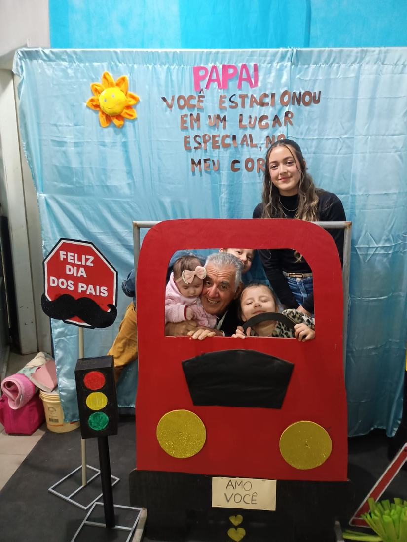 Sinval e os netos num painel de Dia dos Pais, dentro de um carro de papelão