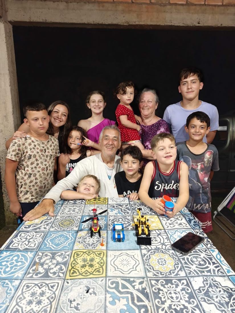 Família numa mesa de azulejos, com muitas crianças