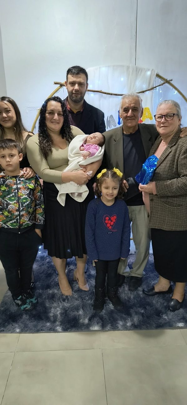 Família reunida em uma sala, com bebê e crianças