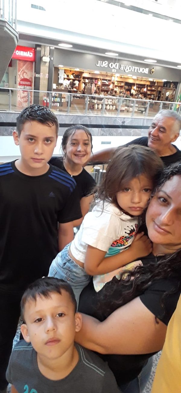 Selfie num shopping, com Sinval ao fundo sorrindo para os netos