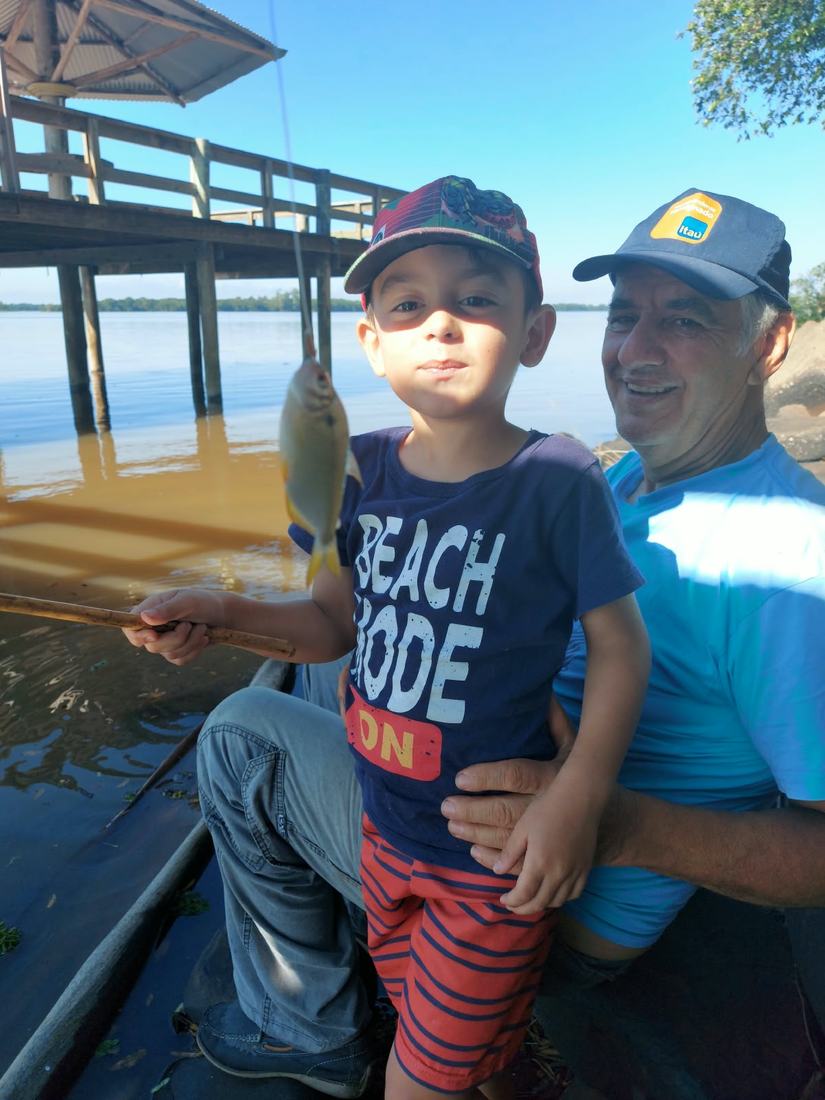 Um senhor e um menino pescando num deque