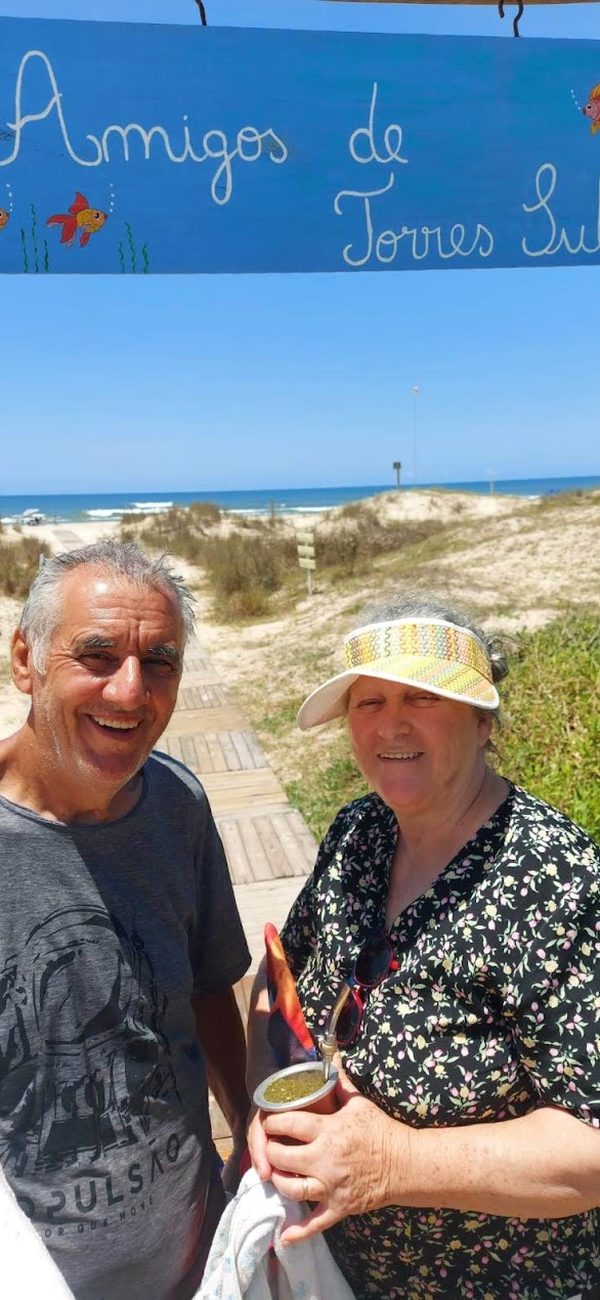 Sinval e uma mulher sob a placa Amigos de Torres Sul