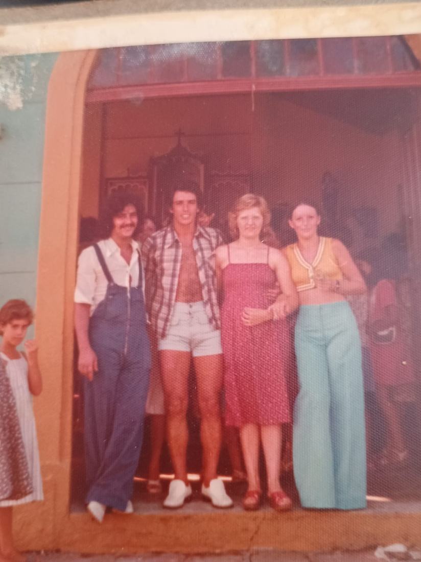 Fotografia antiga de um grupo de jovens diante de uma casa