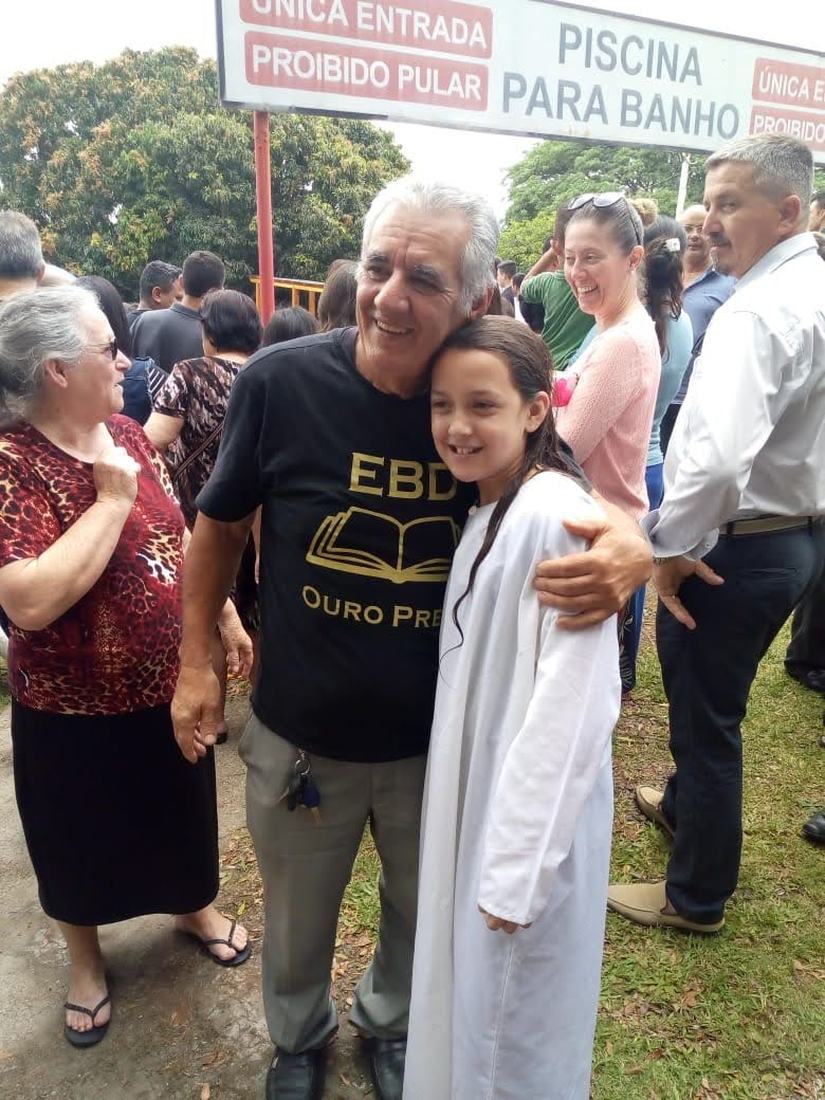 Sinval em um encontro da igreja, ao lado de uma menina de roupa branca