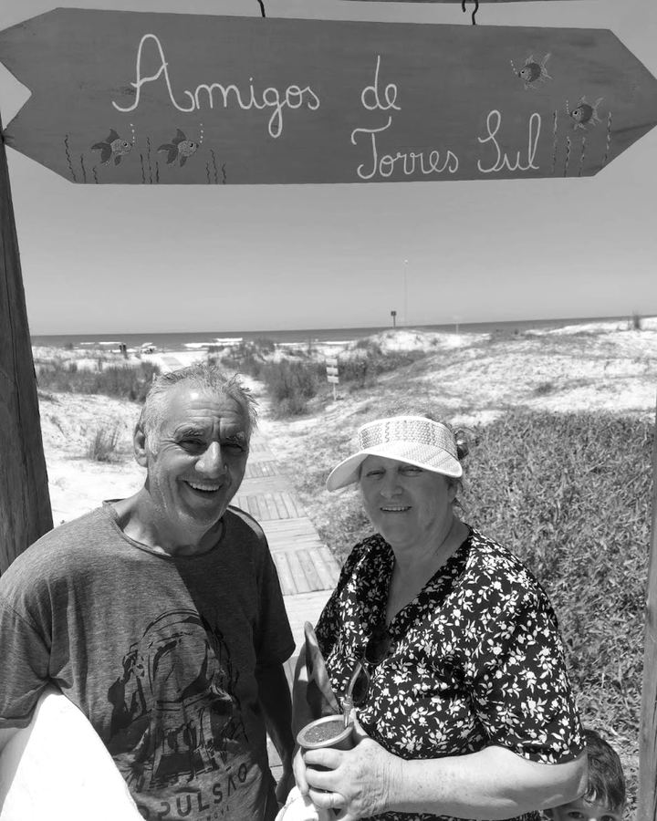Sinval e uma mulher sob a placa Amigos de Torres Sul